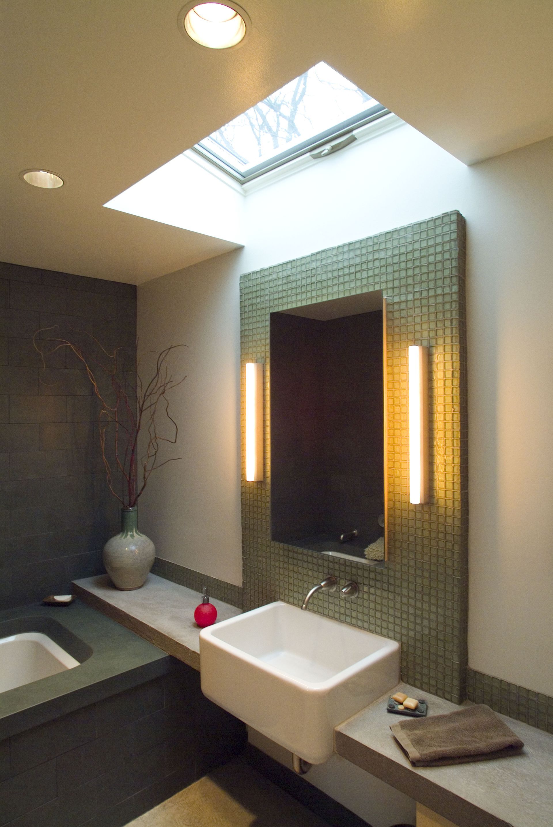 A bathroom with a sink and a skylight above it