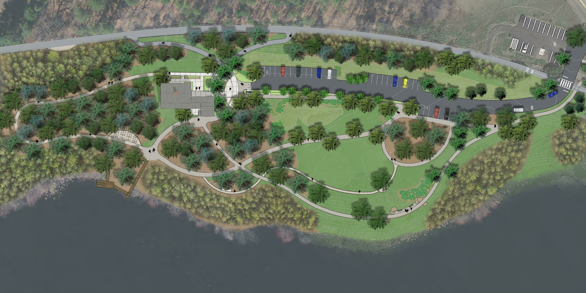 An aerial view of a park surrounded by trees and a body of water.