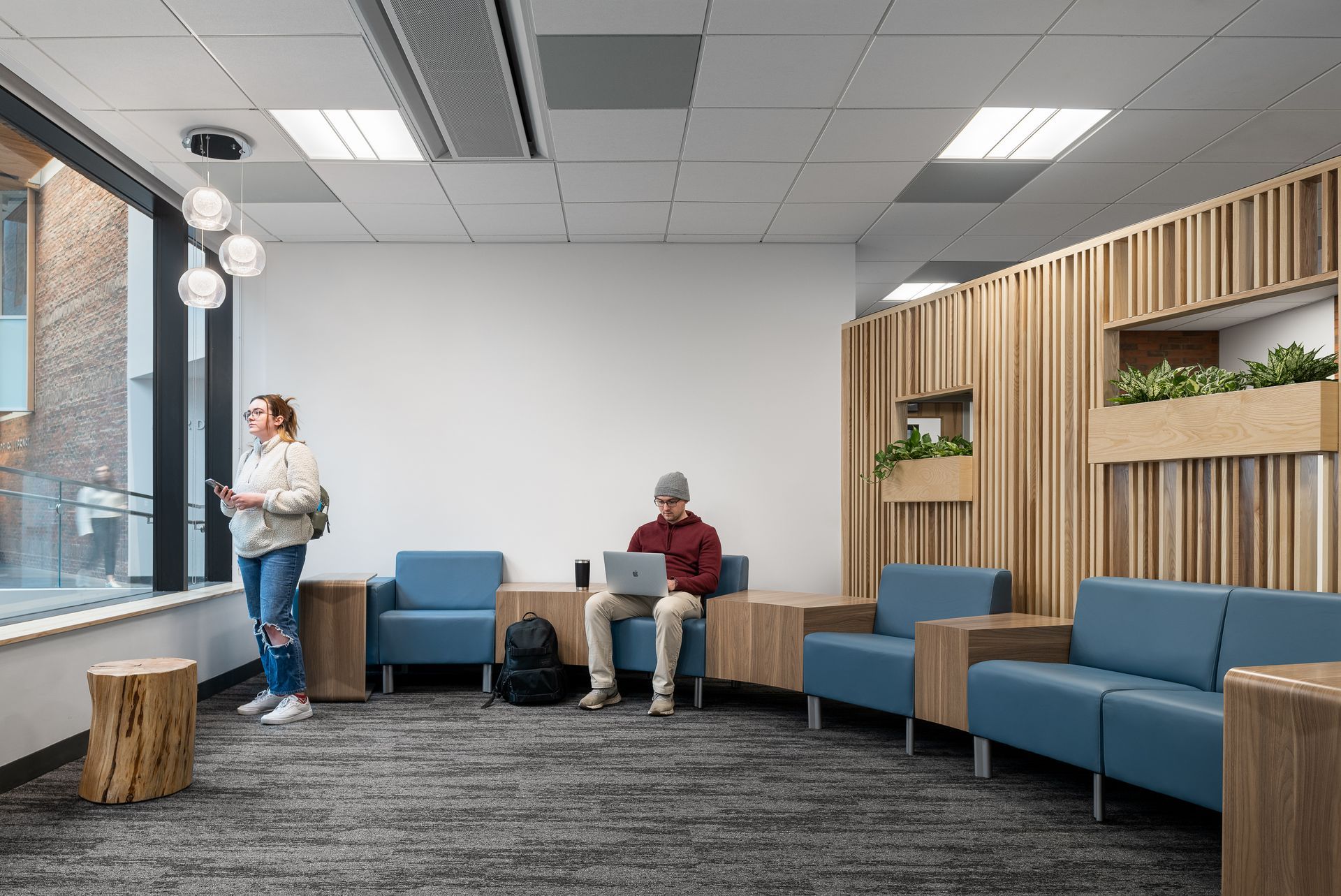 A man and a woman are sitting in chairs in a waiting room.