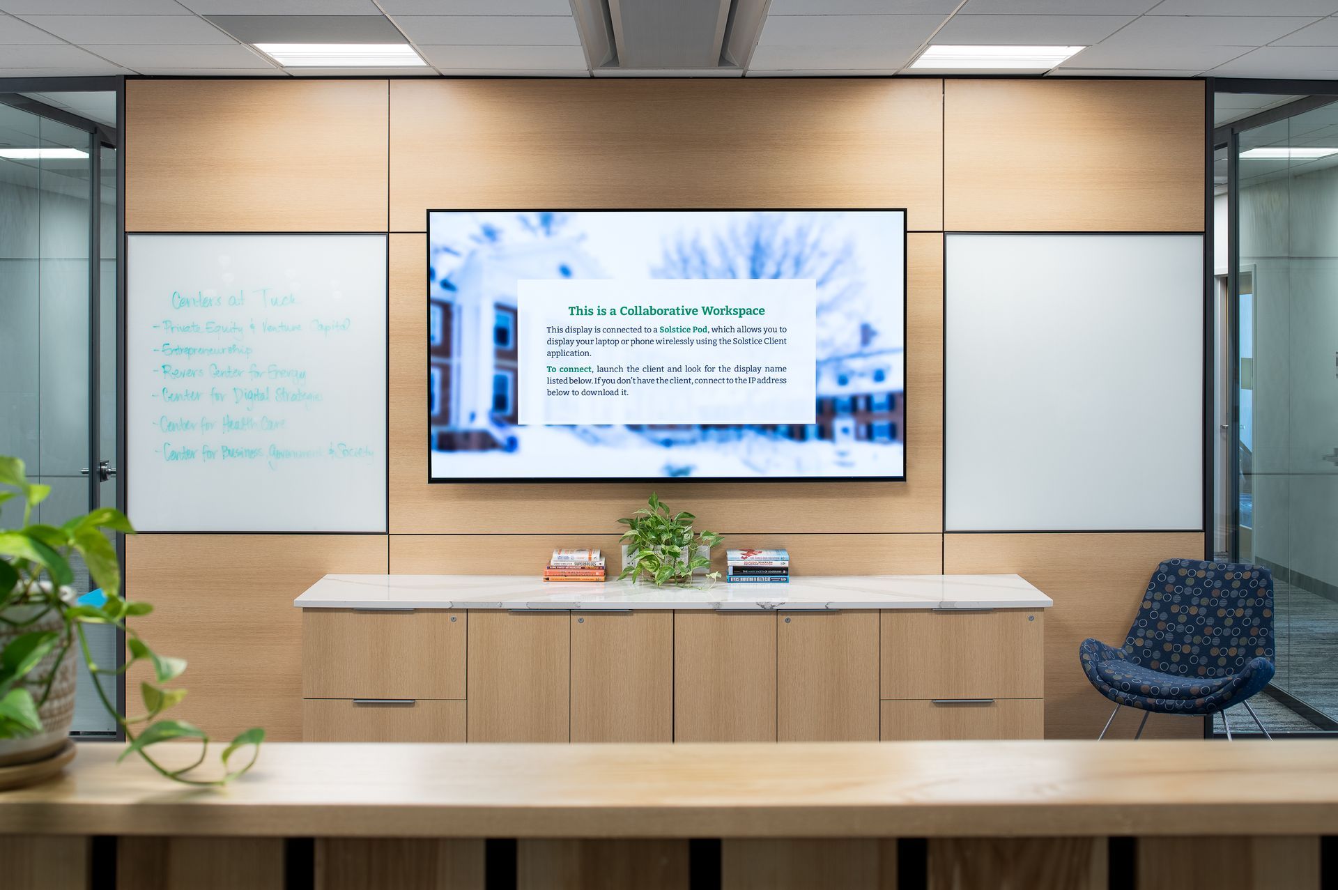 A large flat screen tv is hanging on a wall in a room.
