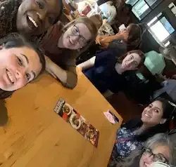 a group of women are sitting at a table in a restaurant .