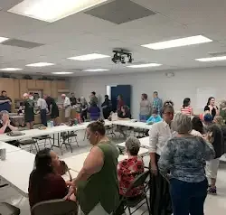 a large group of people are sitting at tables in a room .