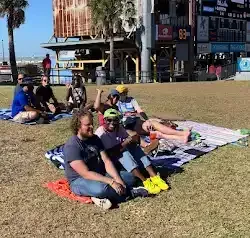 a group of people are sitting on blankets in a park .
