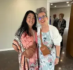 two women are posing for a picture together in an empty room .
