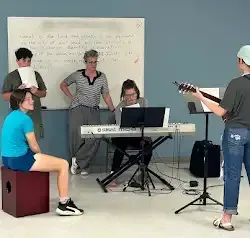 a group of people are playing instruments in a room .