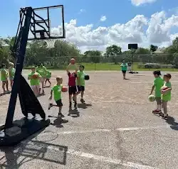 a group of children are playing basketball on a court .