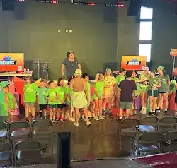 a group of people are standing on a stage in a room .
