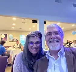 a man and a woman are posing for a picture in a restaurant .