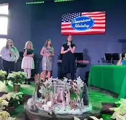 a group of women are standing in front of a large american flag .