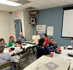 a group of people are sitting around a table in a room .