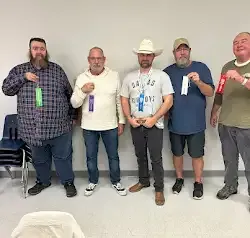 a group of men are standing next to each other in a room .