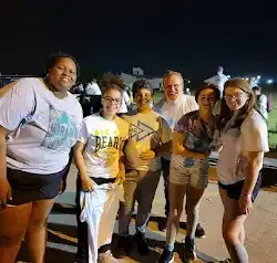 a group of people are posing for a picture together at night .