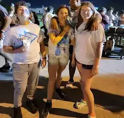 a group of people are standing next to each other on a sidewalk .