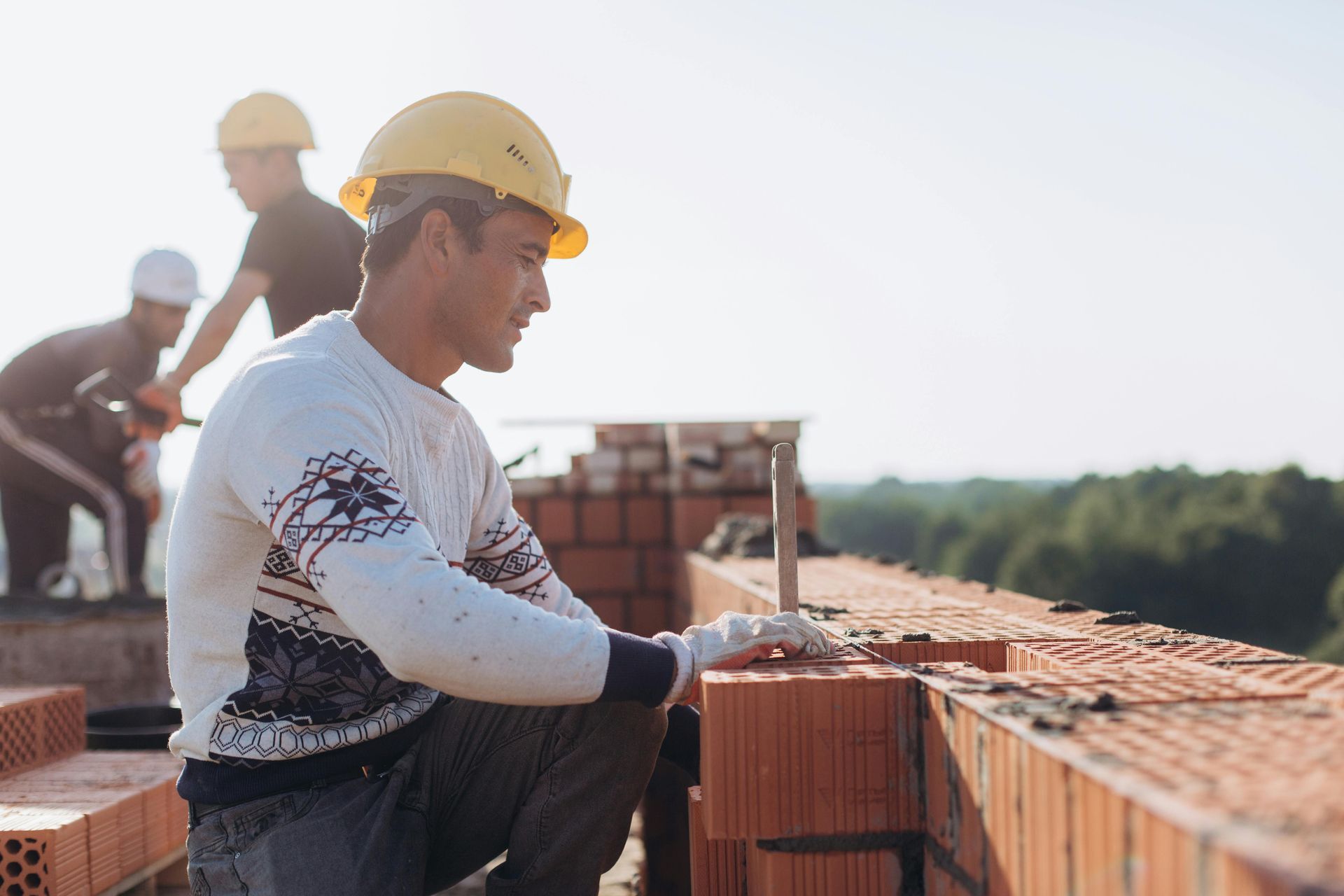 A group of construction workers are working on a brick wall.