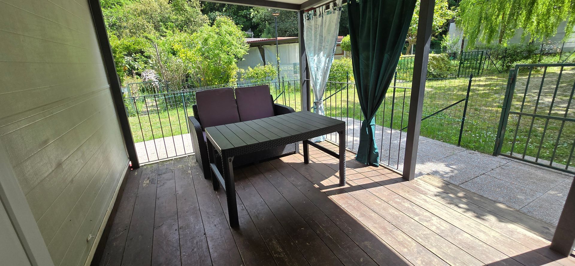 Veranda zitgedeelte en groene achtergrond.