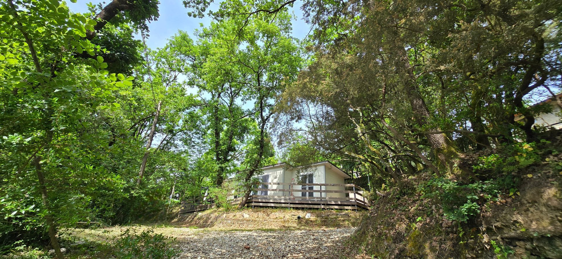 Luxe chalet te midden van weelderig groen met een houten terras.