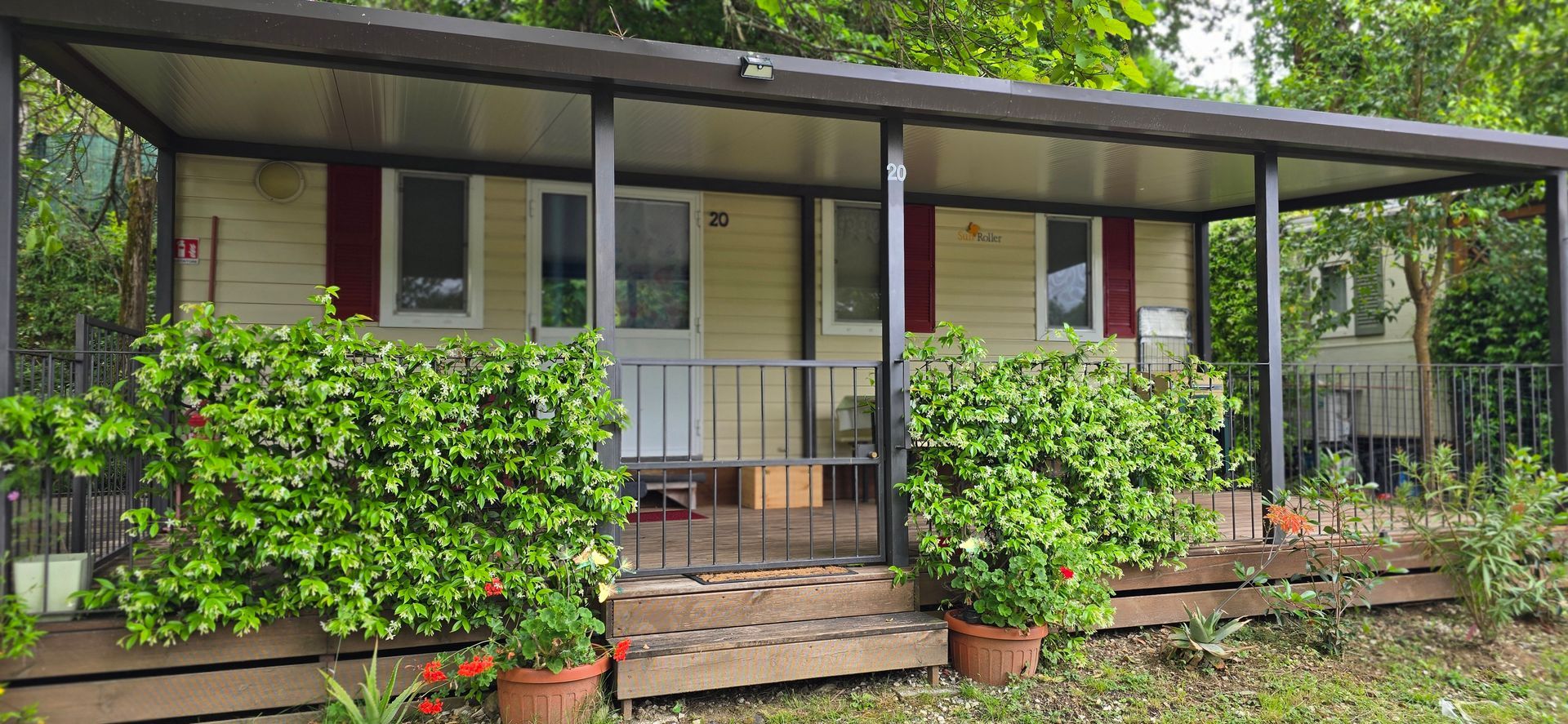 Chalet Lucio  met een overdekte veranda, omgeven door groen.