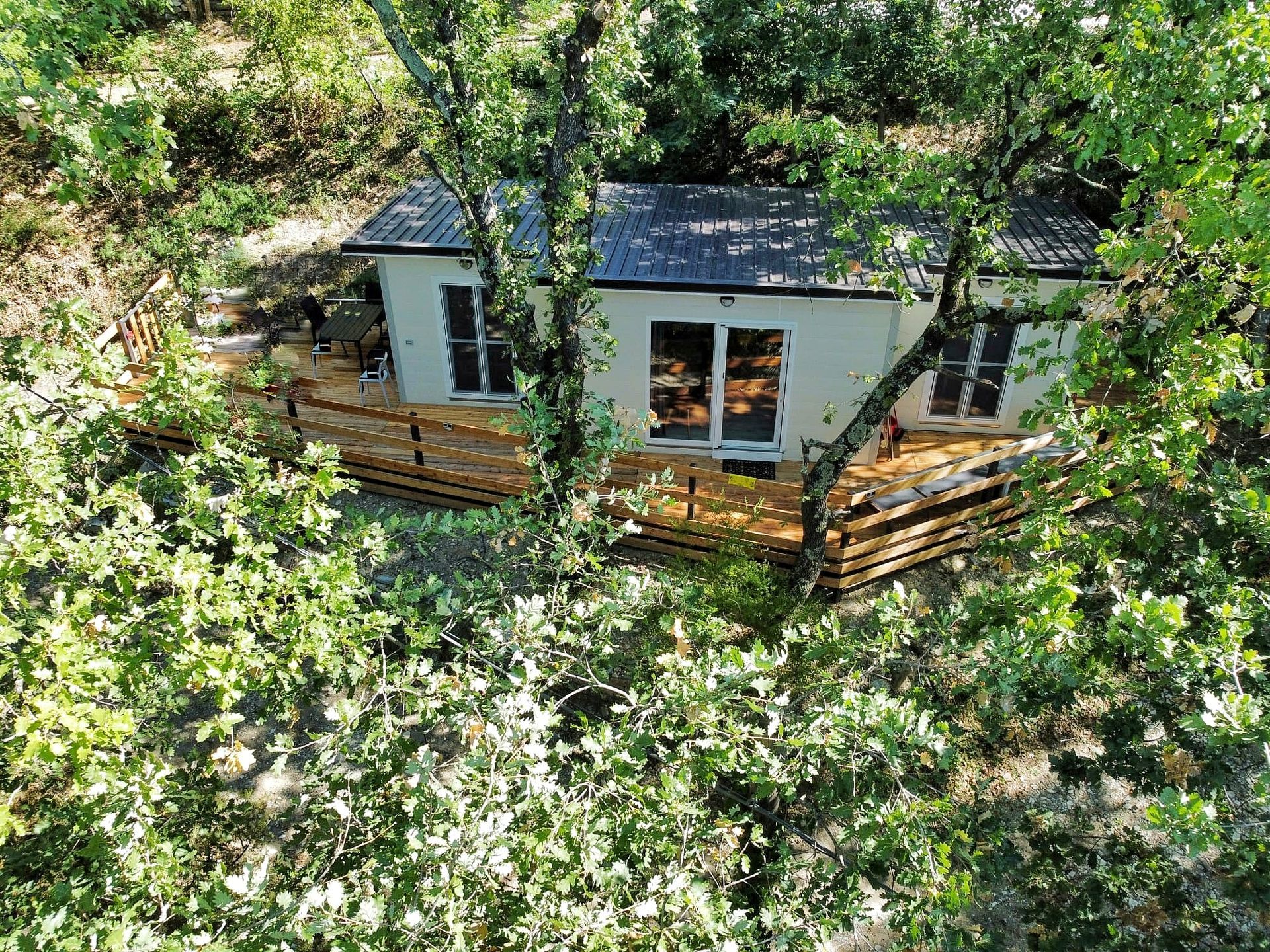 Luxe chalet te midden van weelderig groen met een houten terras.