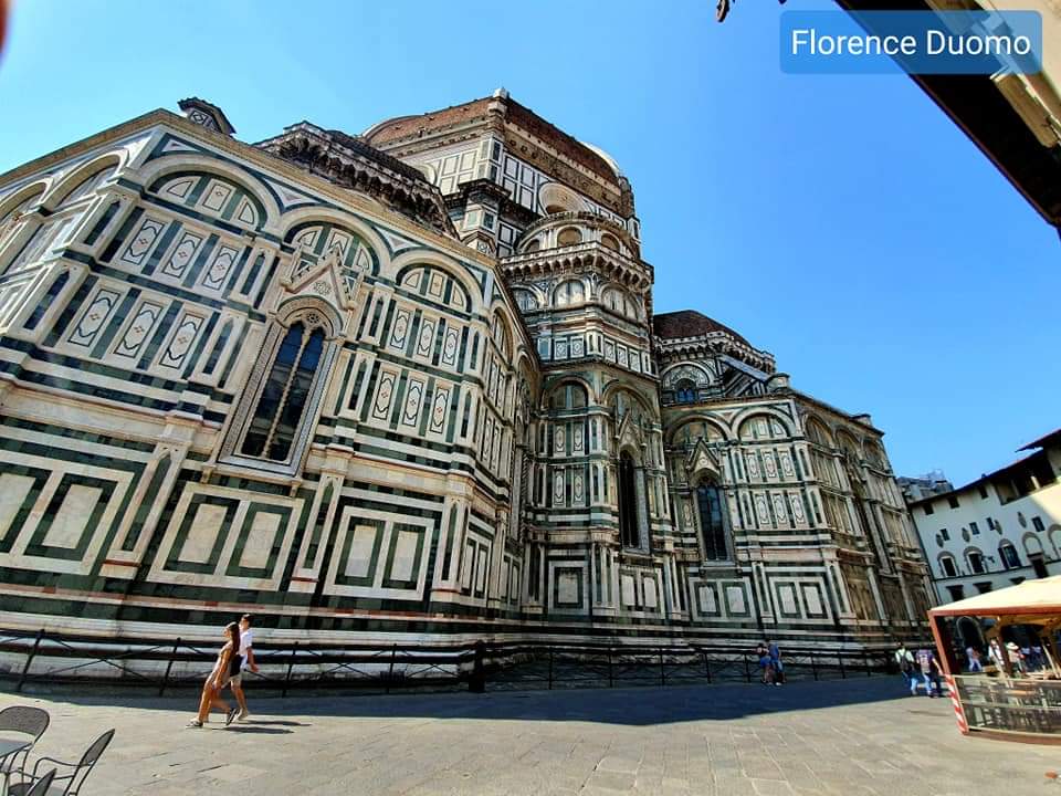 De Dom van Florence, exterieur van de kathedraal met een gevel van wit en groen marmer, blauwe lucht.