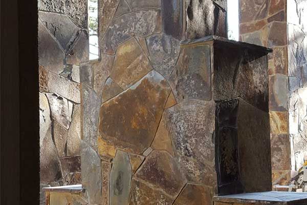 A stone wall with a chimney in the middle of it