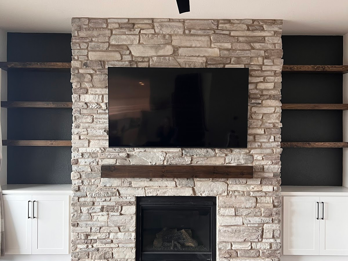 A living room with a brick fireplace and a flat screen tv above it