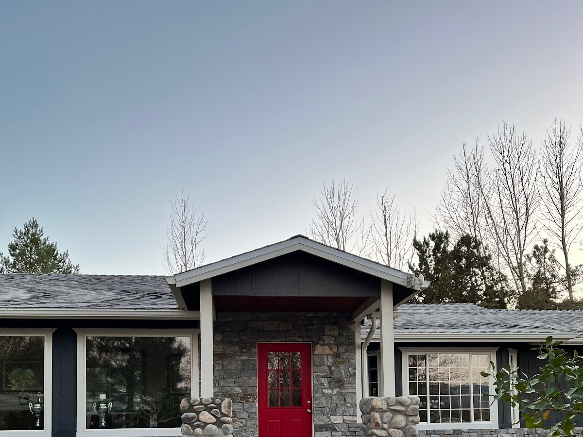The front of a house with a red door and a gray roof