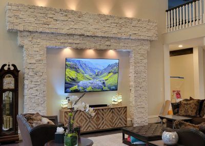A living room with a fireplace and a flat screen tv on the wall.