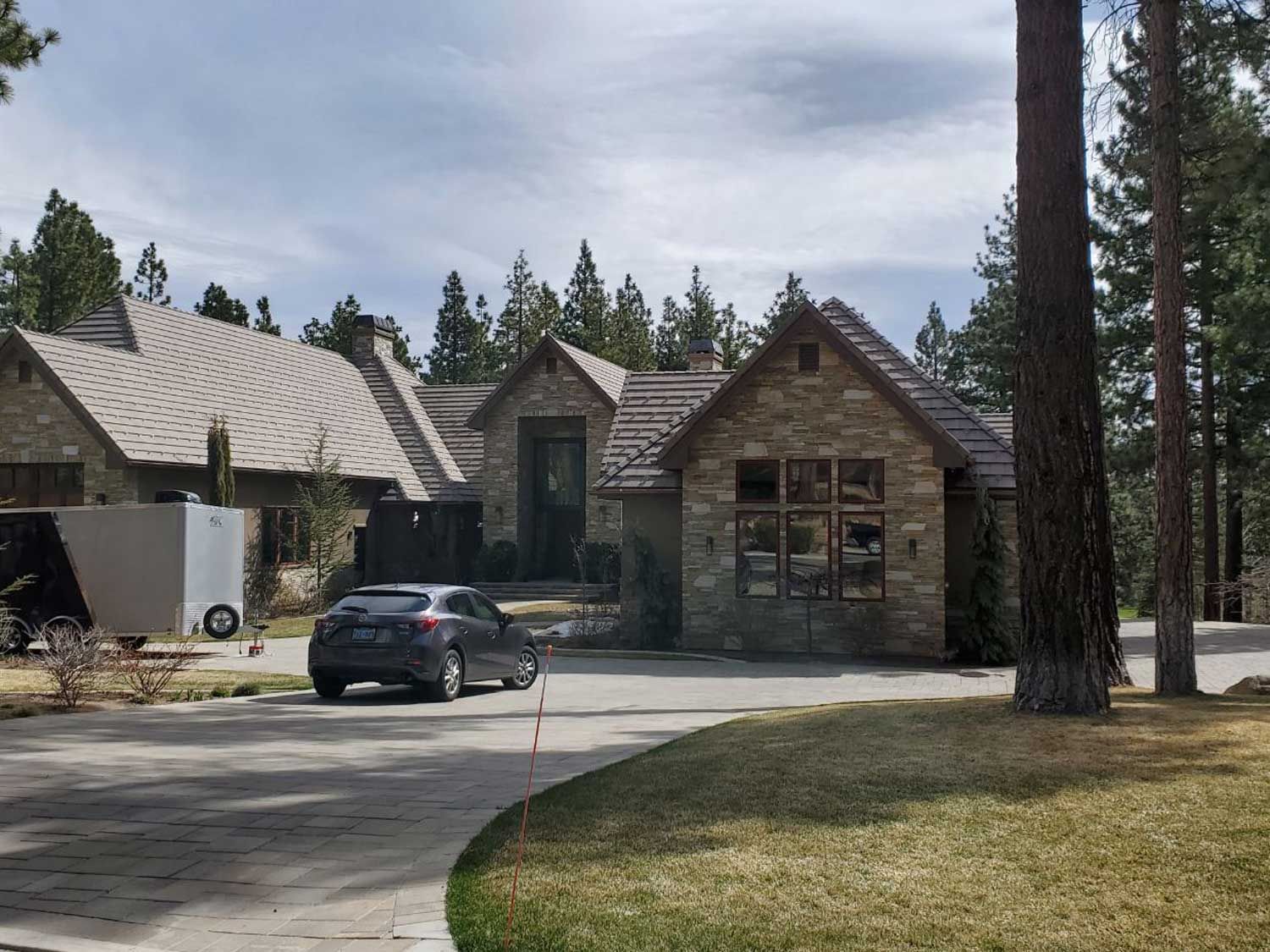 A car is parked in front of a large house