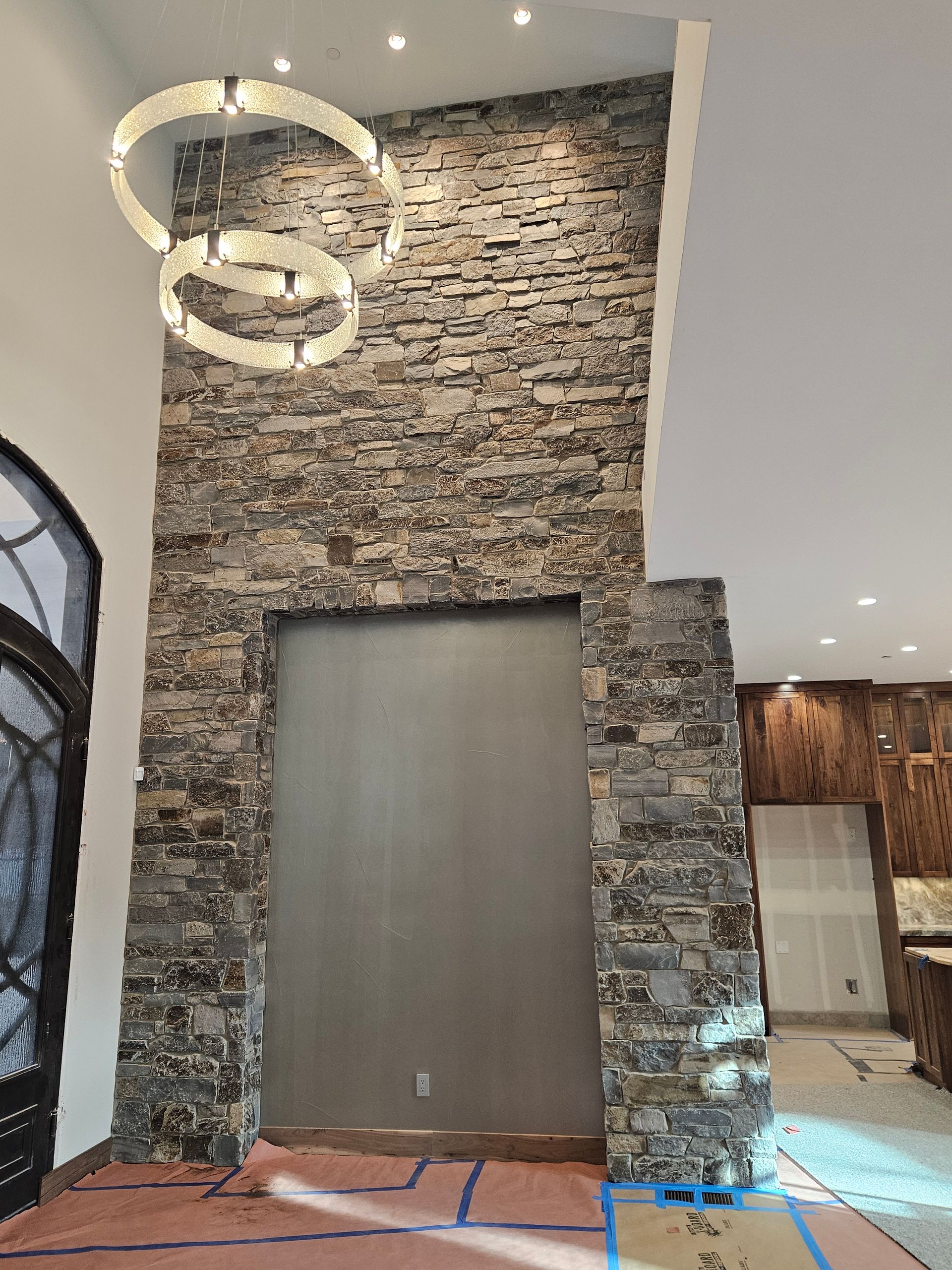 A room with a stone wall and a chandelier hanging from the ceiling