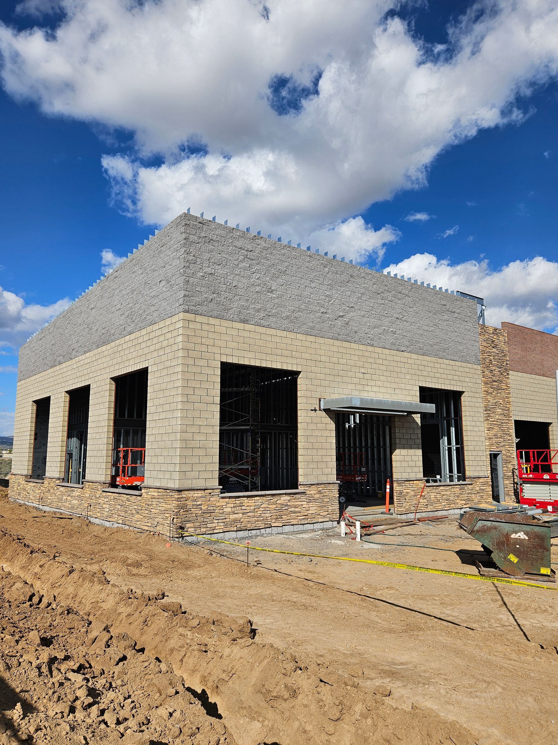 A large building is being built in a dirt field
