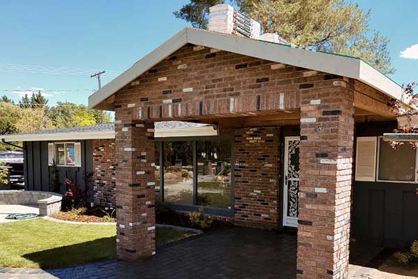 A brick house with a porch and a white roof