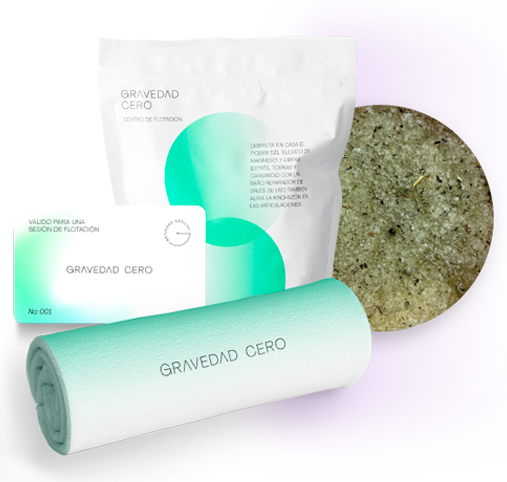 Productos de spa: bolsa y tarjeta con la marca “GRAVEDAD CERO”, toalla turquesa enrollada y sales de baño granuladas.
