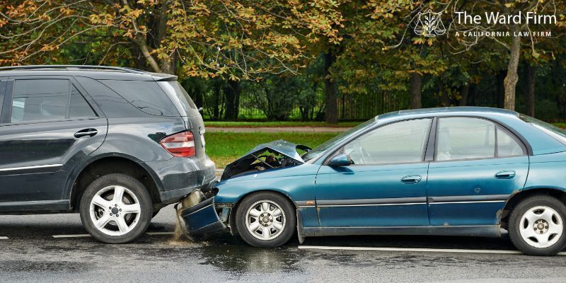 Two vehicles involved in a rear-end collision on a wet road.