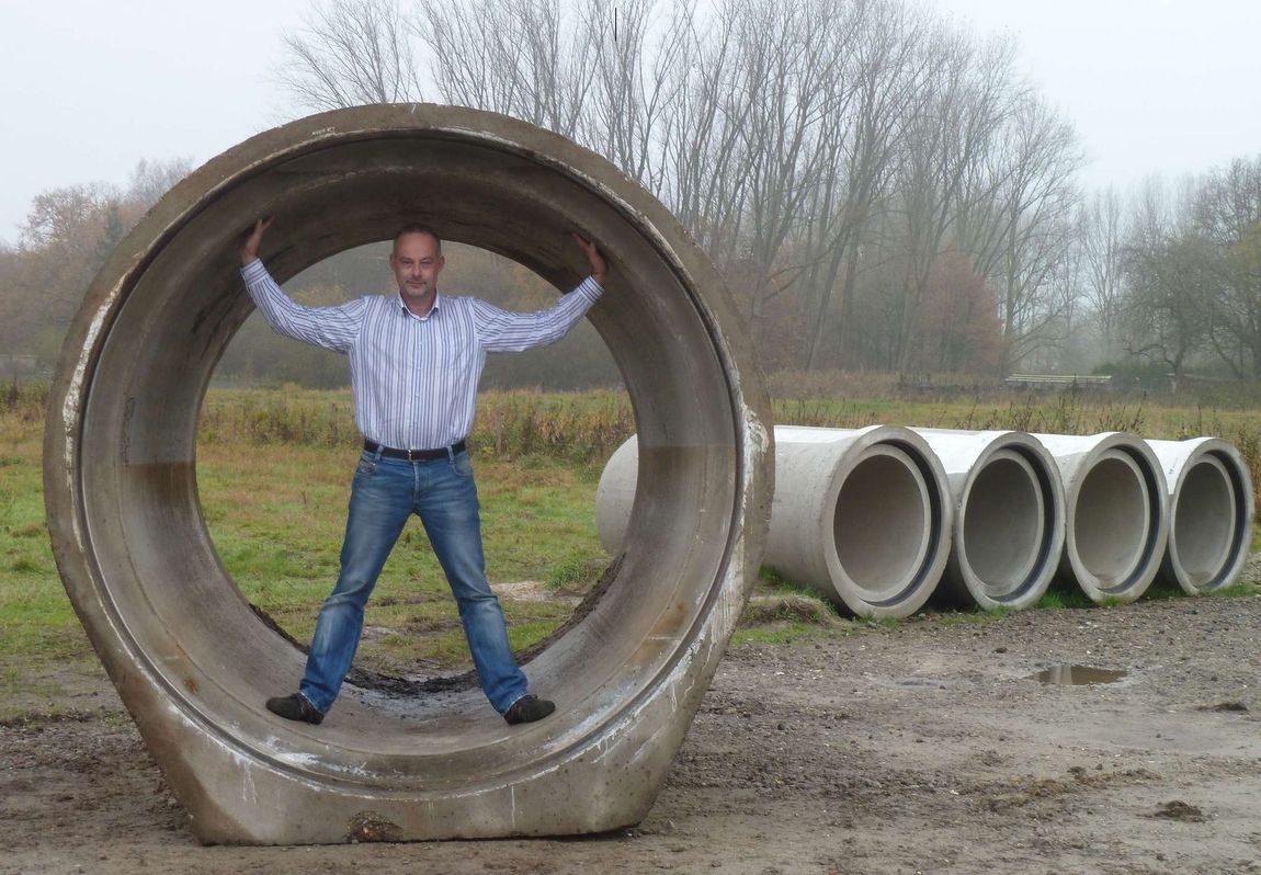 Een man staat in een grote betonnen buis