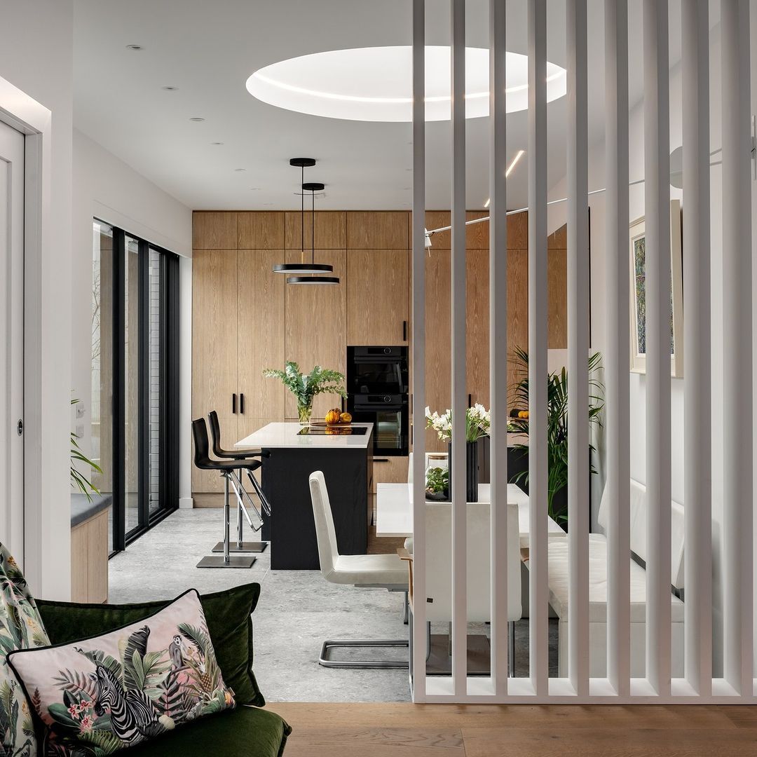 A living room and dining room are separated by a white divider.