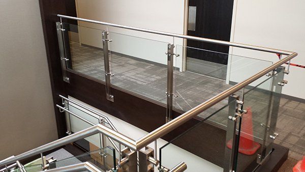 A Staircase with A Glass Railing and A Stainless Steel Railing