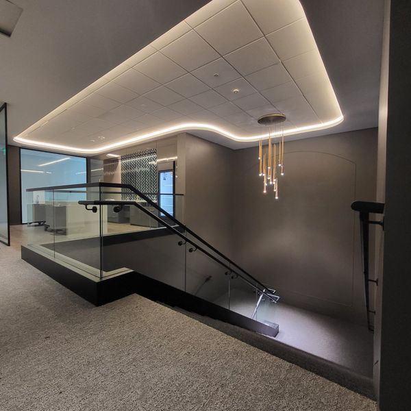 A Staircase with A Glass Railing and A Lighted Ceiling