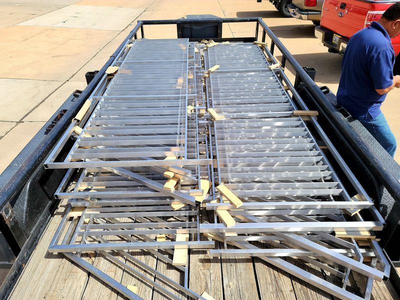 A Man Is Standing Next to A Truck with A Bunch of Metal Pieces on It