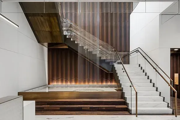 A Staircase with A Glass Railing and Wooden Steps in A Building