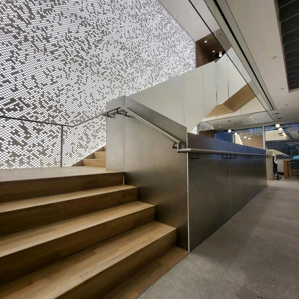 A staircase in a building with a stainless steel railing