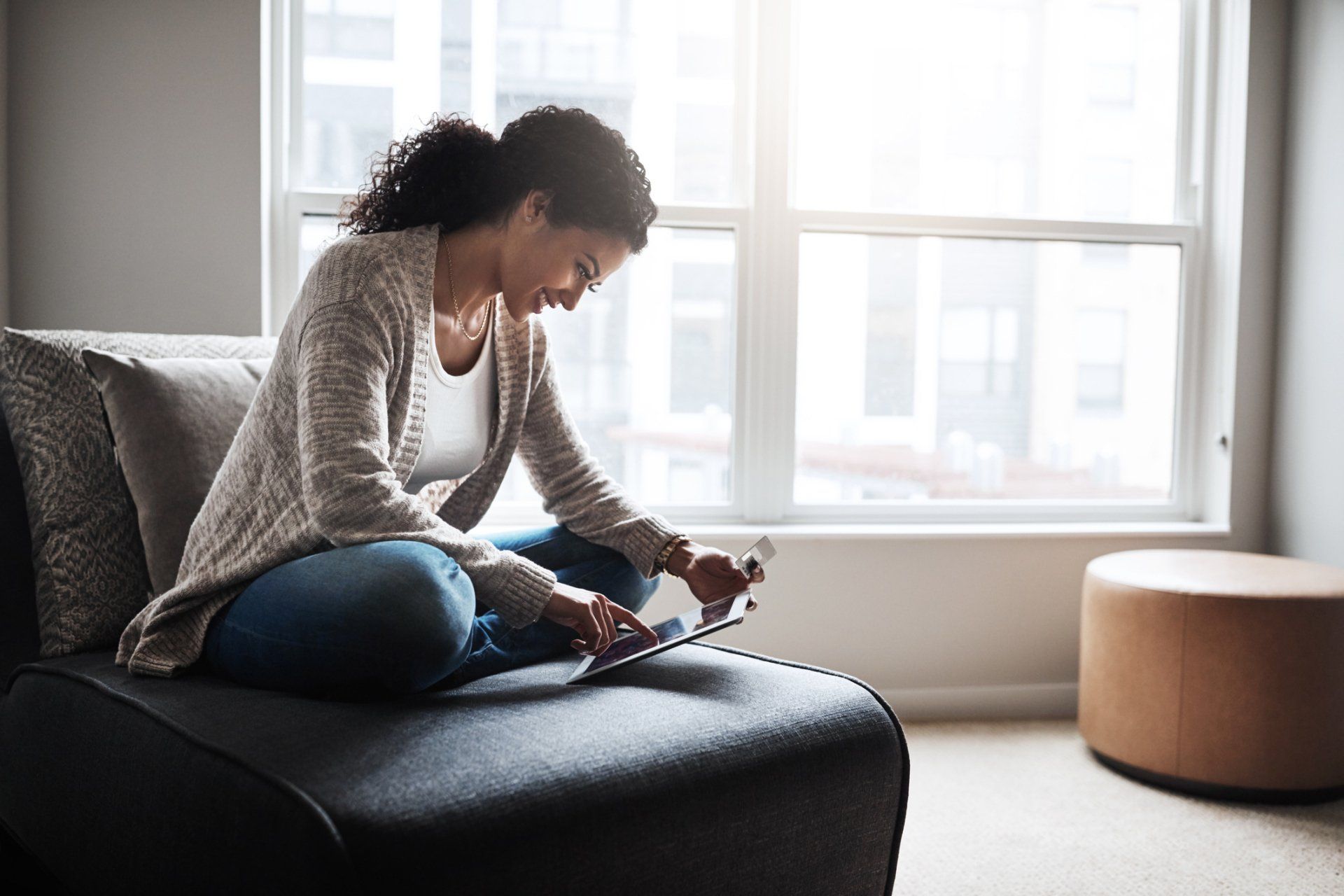 Woman smiling while looking at tablet