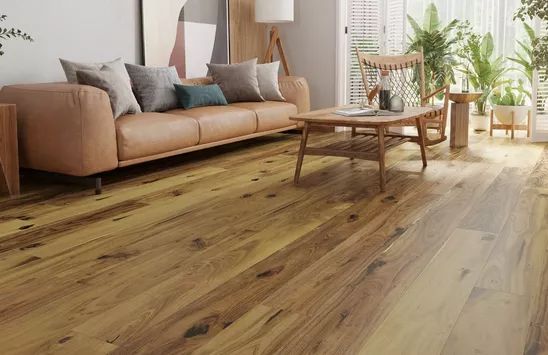 A living room with hardwood floors , a couch and a coffee table.