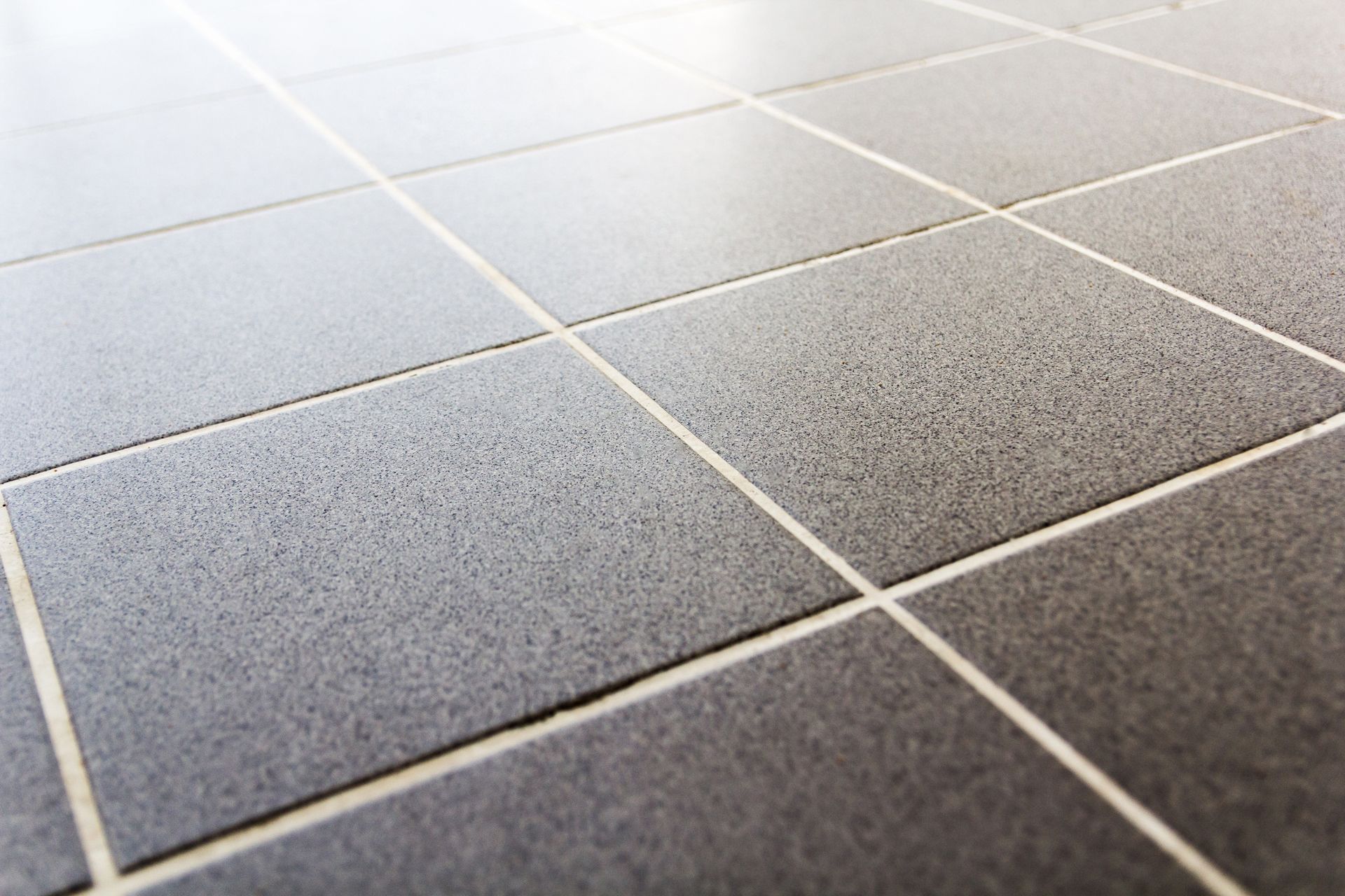 A close up of a tiled floor with white grout