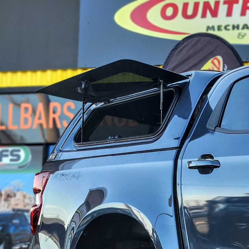 Silver pickup truck with a canopy and roof rack.