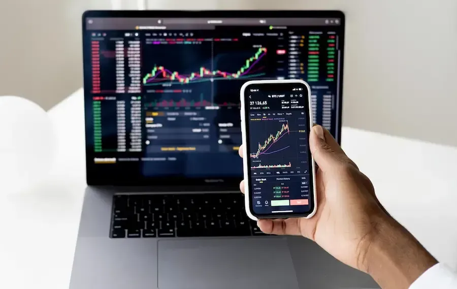 Computer screen and cell phone both showing growth on a chart from digital marketing.