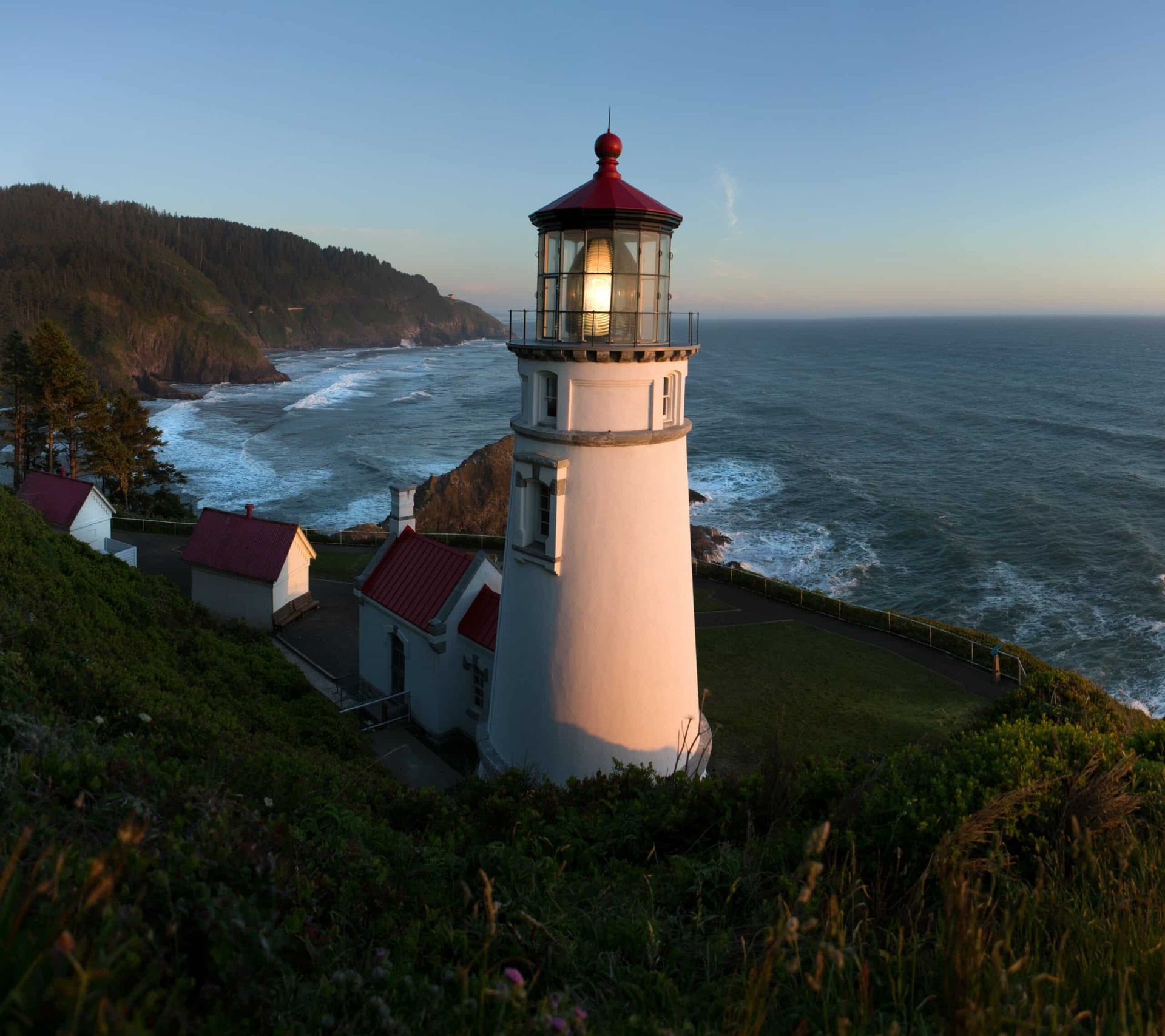 A lighthouse sits on a cliff overlooking the ocean