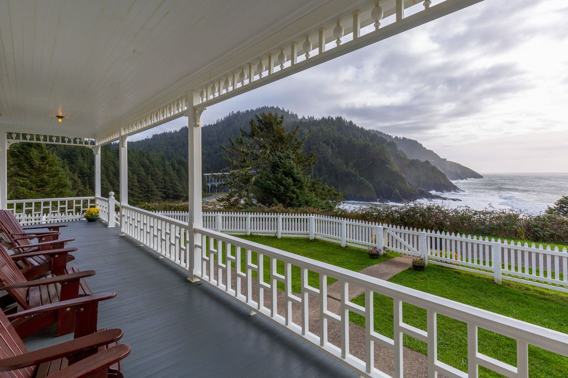 A large porch with a view of the ocean and mountains.