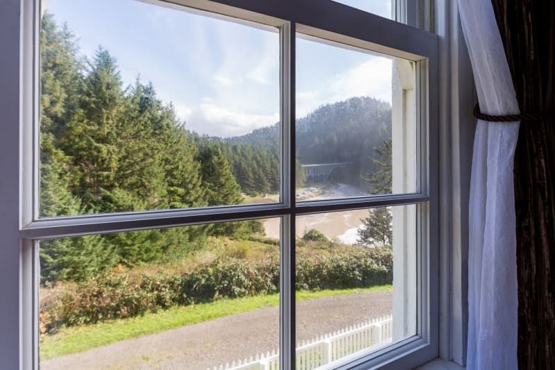 A window with a view of a forest and mountains.