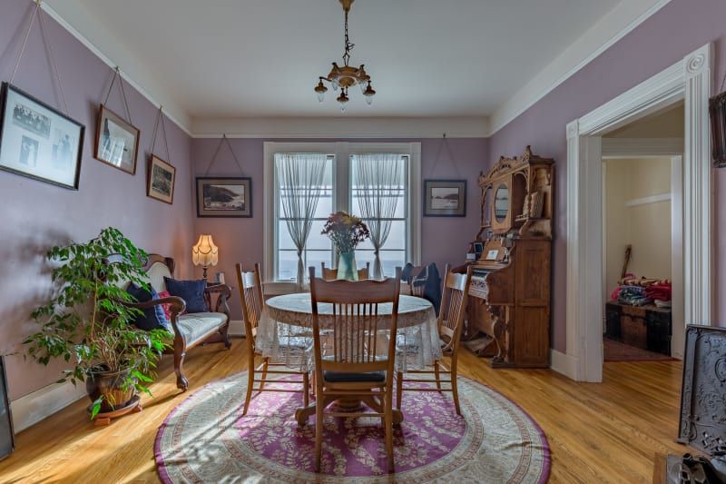 A dining room with a table and chairs and purple walls.