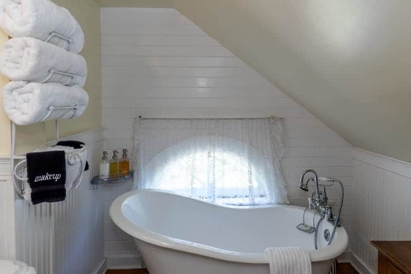 A bathroom with a claw foot tub and a window.